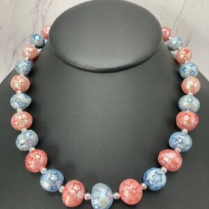 Star shaped machine marks (star kisses) created on red and blue pearls.